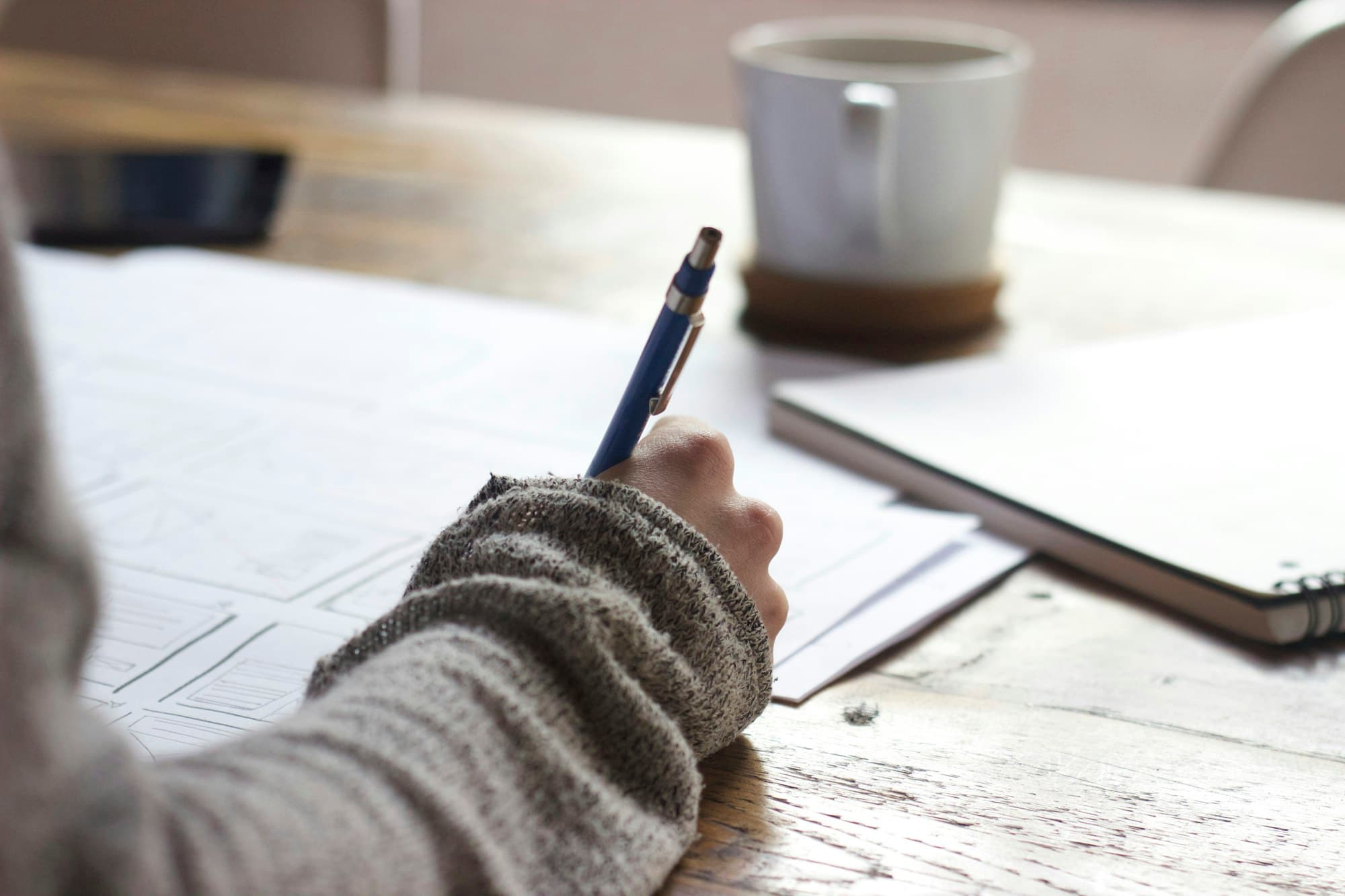 Student writing notes at a desk